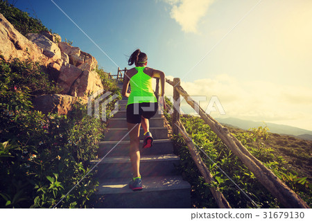 woman runner running upstairs on mountain stairs 31679130