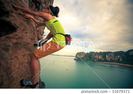 young woman rock climber climbing on cliff young woman rock climber climbing on cliff 31679371