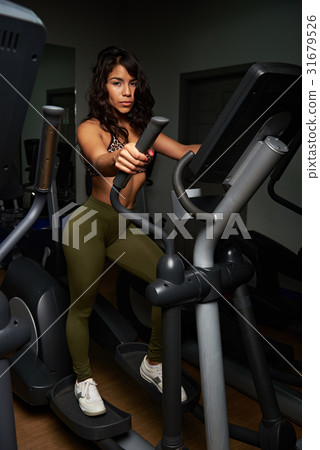 Young woman in elliptical machine Young woman in elliptical machine 31679526