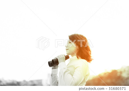 A woman with binoculars A woman with binoculars 31680371
