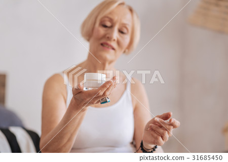 Well-groomed old woman handing her new cream 31685450