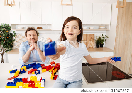 Upbeat girl holding out a construction set piece 31687297