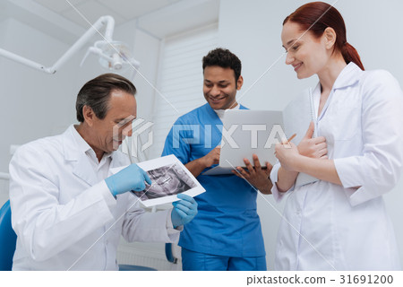 Competent stomatologist showing X-ray image Competent stomatologist showing X-ray image 31691200