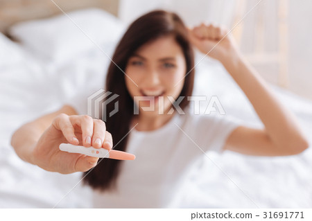 Selective focus on pregnancy test in female hands 31691771