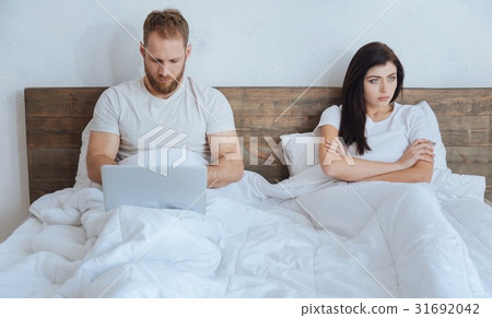 Couple ignoring each other in bed 31692042