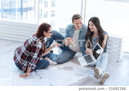 Happy cheerful architects discussing a picture Happy cheerful architects discussing a picture 31692186