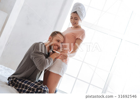 Man listening his baby moves in tummy 31692546