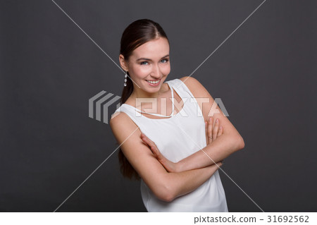 Smiling woman standing with crossed arms 31692562