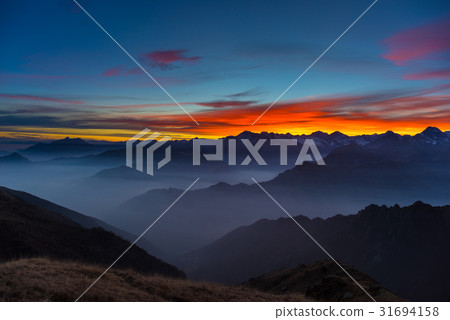 Last warm sunlight on alpine valley 31694158