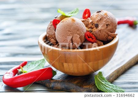 Balls of chocolate ice cream with chilli in bowl. 31694662