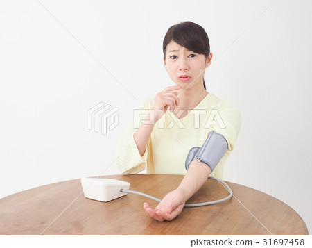 A woman surprised measuring blood pressure 31697458