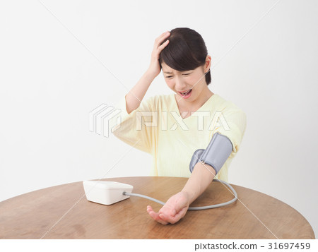 A woman surprised measuring blood pressure 31697459