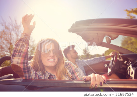 Couple of lovers driving on a convertible car - 31697524