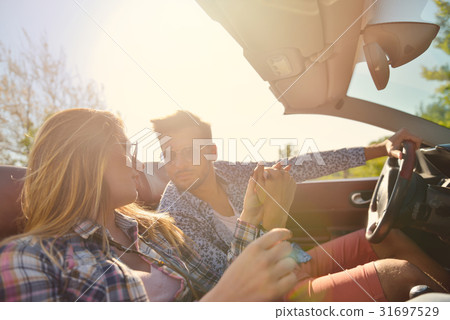 Couple of lovers driving on a convertible car - Couple of lovers driving on a convertible car - 31697529