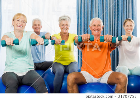 Seniors using exercise ball and weights Seniors using exercise ball and weights 31707755