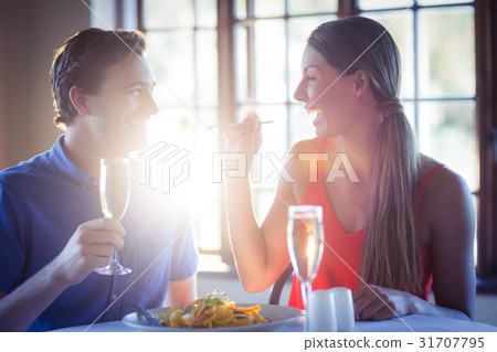 Young woman feeding her man in the restaurant 31707795