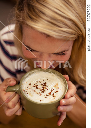 Woman drinking a hot beverage Woman drinking a hot beverage 31707902