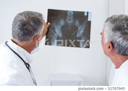 Male doctor discussing x-ray with senior man Male doctor discussing x-ray with senior man 31707945