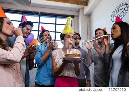 Happy coworker blowing candles for birthday Happy coworker blowing candles for birthday 31707950