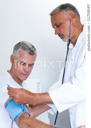 Doctor checking senior mans blood pressure 31708045