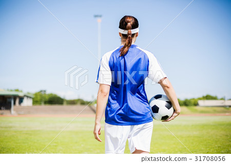 Rear view of soccer player standing with a ball 31708056