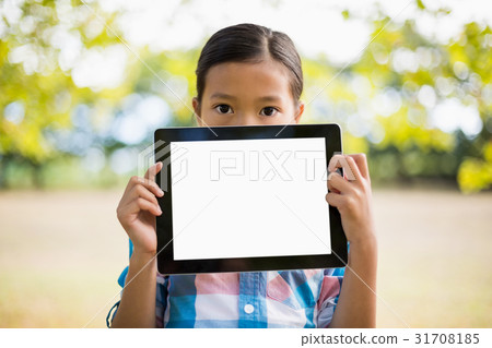 Portrait of girl showing digital tablet in park Portrait of girl showing digital tablet in park 31708185