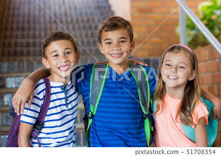 Smiling school kids standing with arm around Smiling school kids standing with arm around 31708354