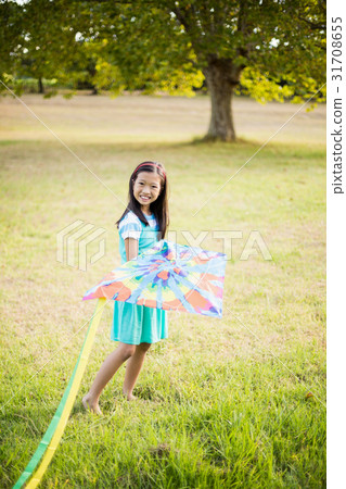 Portrait of smiling girl playing with kite in park Portrait of smiling girl playing with kite in park 31708655