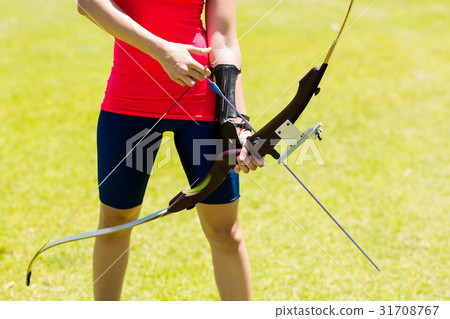 Mid-section of female athlete practicing archery Mid-section of female athlete practicing archery 31708767