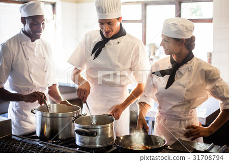 Chefs preparing food at stove Chefs preparing food at stove 31708794