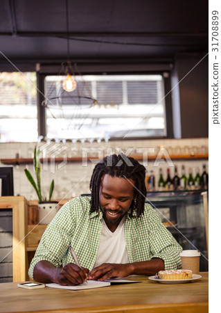 Man writing in a notebook 31708899