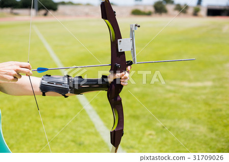 Female athlete practicing archery Female athlete practicing archery 31709026