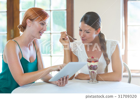 Women discussing with a digital tablet 31709320