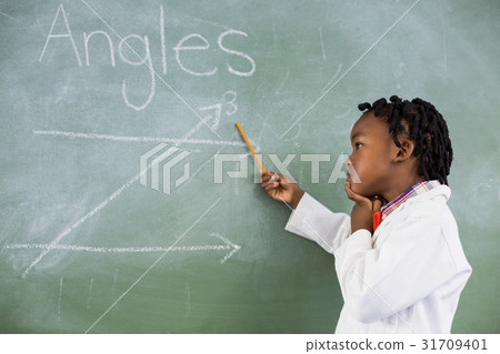 Schoolboy doing mathematics on chalkboard in classroom 31709401