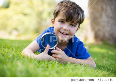 Boy holding a magnifying glass Boy holding a magnifying glass 31709710