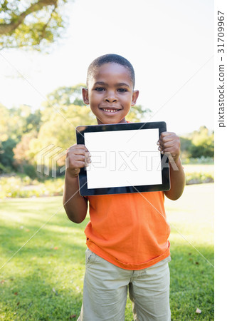 Happy child holding tablet pc while standing 31709967