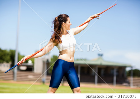 Female athlete carrying javelin on her shoulder 31710073