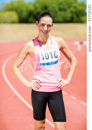 Portrait of female athlete standing with hands on hips 31710101