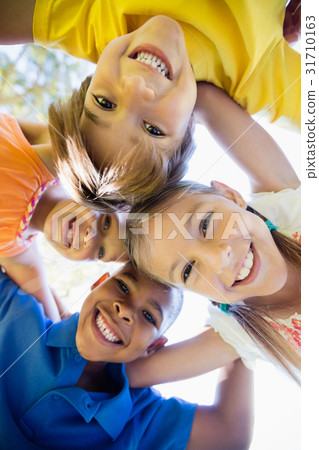 smiling children forming a huddle in circle 31710163