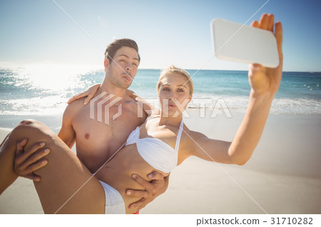 Young couple taking selfie on beach 31710282