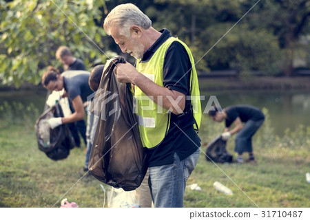 Diverse Group of People Pick Up Trash in The Park Volunteer Comm Diverse Group of People Pick Up Trash in The Park Volunteer Comm 31710487