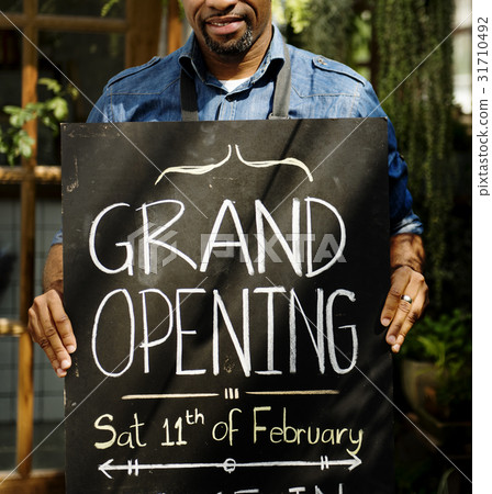 Adult Man Standing with Grand Opening Sign 31710492
