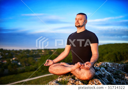 Portrait of the man sitting on a rock in the lotus Portrait of the man sitting on a rock in the lotus 31714322