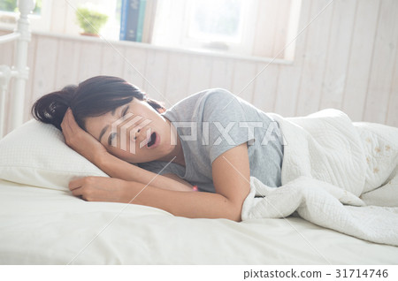 一個女人在床上打哈欠 一個女人在床上打哈欠 31714746