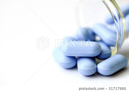 Blue caplets on white background. 31717988