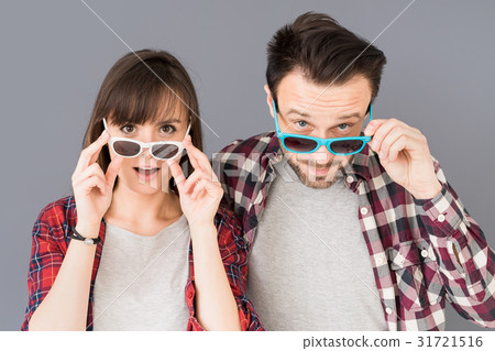 A pair of young people leave glasses and opens her mouth in surp 31721516