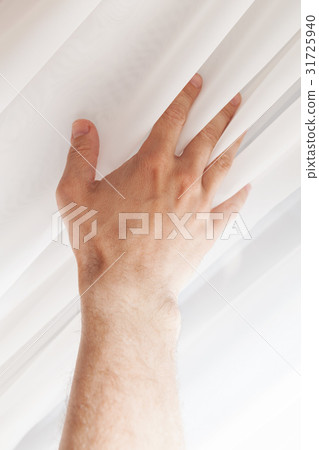 Hand and soft white tulle on window 31725940