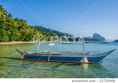 Traditional banca boat in clear water at sandy Traditional banca boat in clear water at sandy 31728406