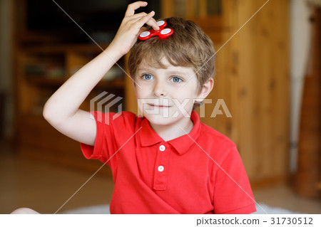 School kid playing with Tri Fidget Hand Spinner School kid playing with Tri Fidget Hand Spinner 31730512