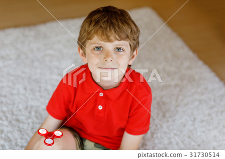 School kid playing with Tri Fidget Hand Spinner School kid playing with Tri Fidget Hand Spinner 31730514